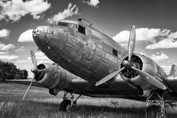 Fine art aviation photography of a dc-3 or c-47 in a field in black and white. 