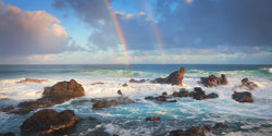 A double rainbow over the the waves of Maui Hawaii. 