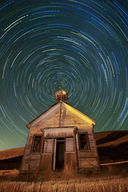 An old schoolhouse with the night sky above it