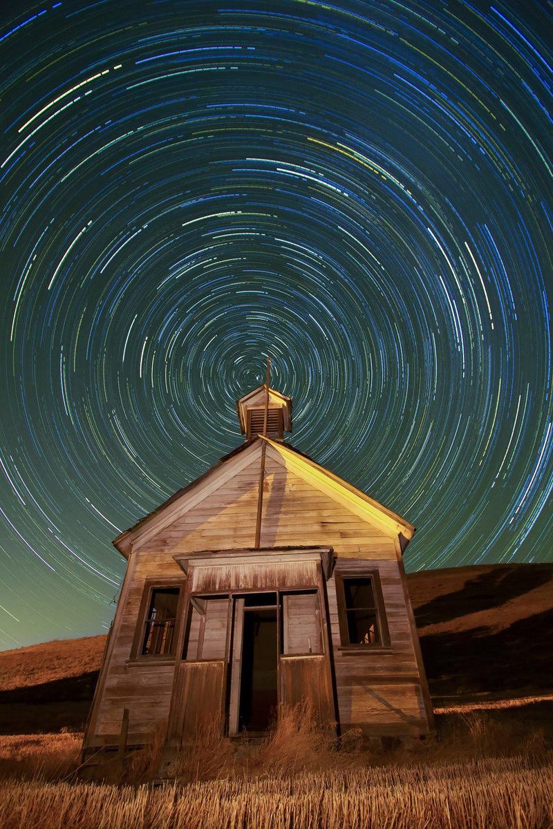 An old schoolhouse with the night sky above it