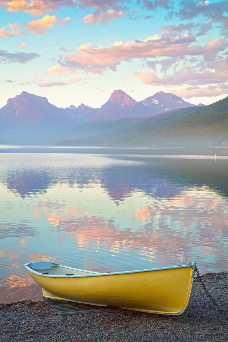 A yellow canoe sits on the shores of Lake McDonald in Glacier National Park