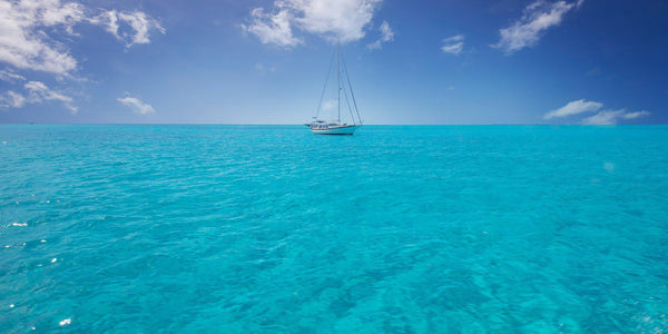 Crystal clear water and a sailboat in The Exumas, Bahamas. By Lijah Hanley. 
