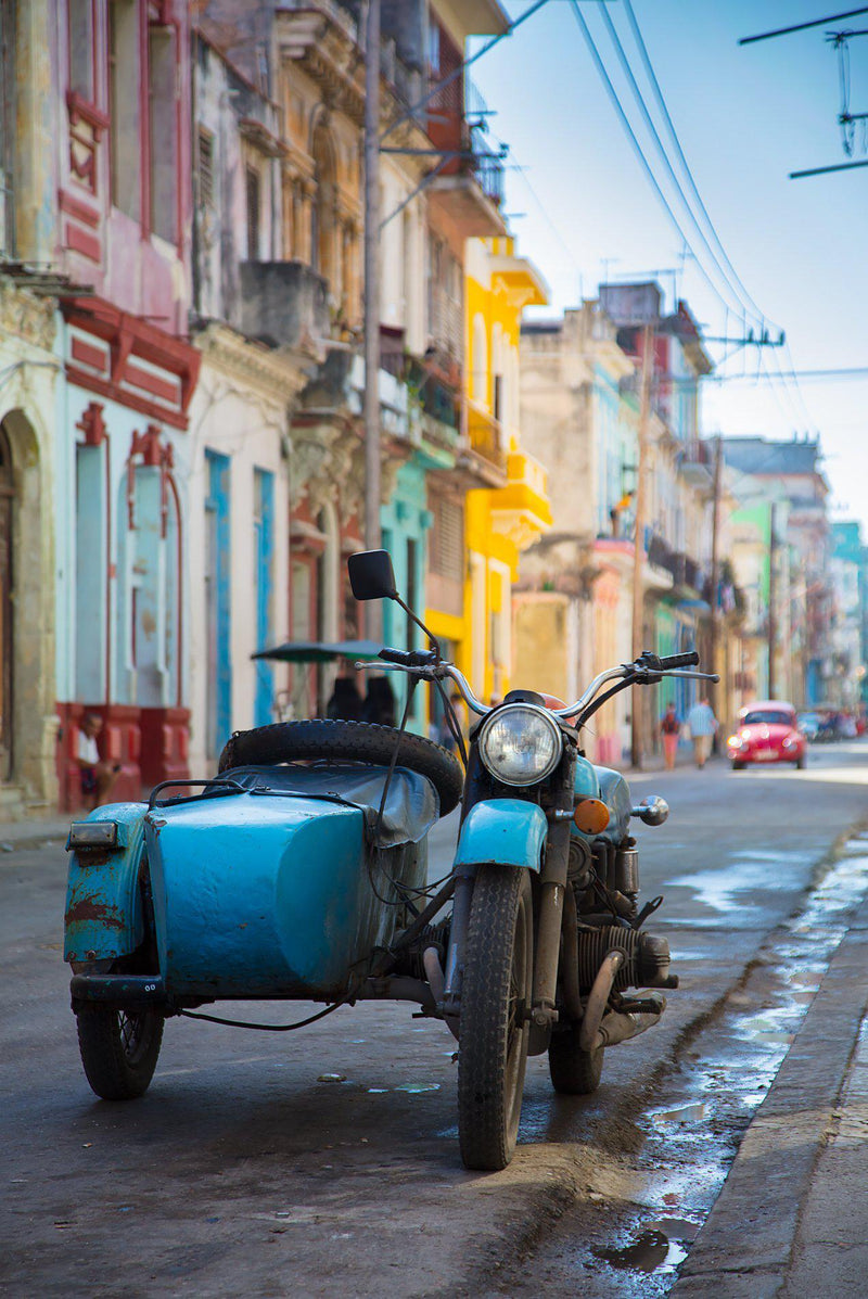 A motorcycle and sidecar sit in the streets in Havana Cuba